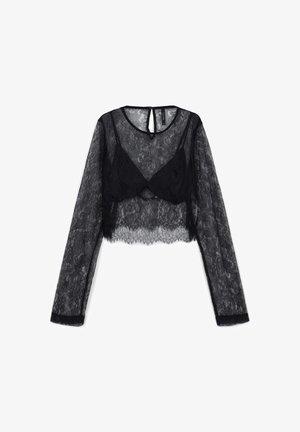 Schwarzes Spitzen-Crop-Top mit langen Ärmeln aus transparentem Stoff, aufwendigen floralen Mustern und einem Schlitz-Rückendetail. Mit welligem Saum.