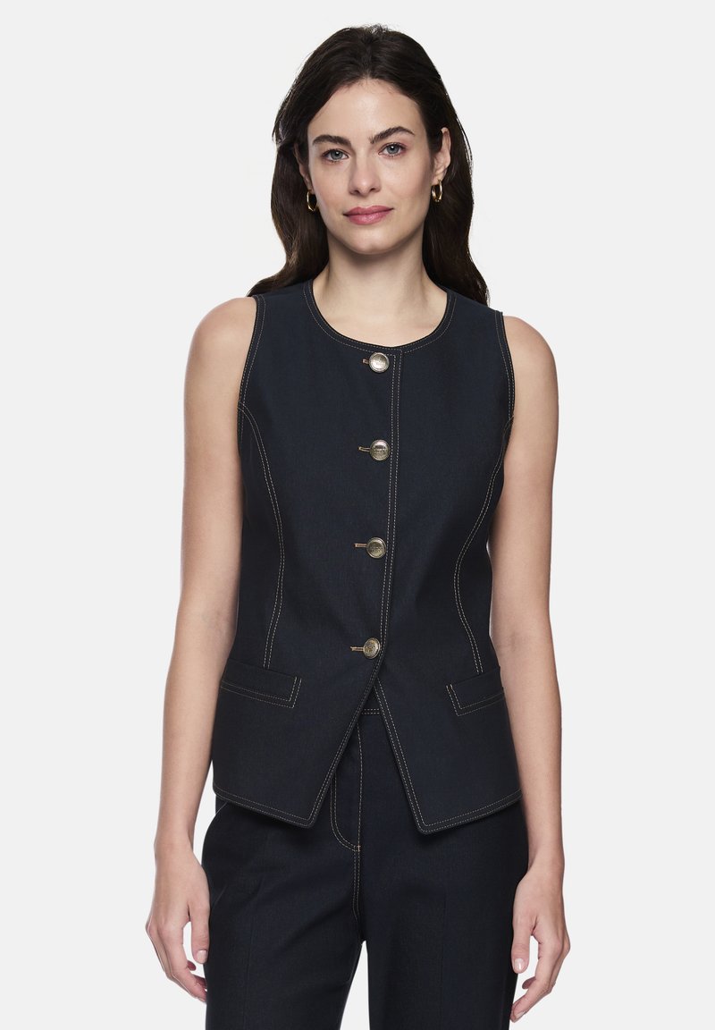 Dunkelblaue ärmellose Jeansweste mit fünf goldfarbenen Knöpfen, kontrastierenden Nähten und zwei Vorder Taschen. Taillierte Passform mit abgerundetem Ausschnitt.