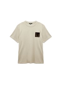 Camiseta de color beige claro hecha de tela texturizada, con un pequeño bolsillo cuadrado negro que presenta un gráfico de una pieza de ajedrez con contorno dorado.