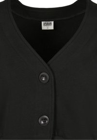 Black cropped cardigan with a v-neck design, featuring two round black buttons and a smooth, thick texture. Label reads "Urban Classics," size XS.