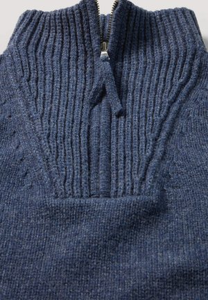 Dunkelblauer Strickpullover mit gerippter Textur, halbem Reißverschluss und auffälligen Nähdetails im gesamten Stoff.