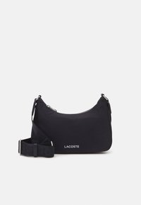 Borsa a spalla nera in nylon con forma curvata, chiusura con zip, tracolla regolabile e logo in rilievo sulla parte anteriore. Texture liscia e design minimale.
