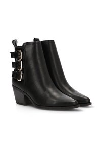 Botas de cuero negro hasta el tobillo con punta afilada, tacón apilado y tres hebillas decorativas plateadas en el costado. Textura suave y diseño elegante.