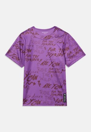 Camiseta morada de manga corta con cuello redondo, con texto en estilo manuscrito de color marrón oscuro y flechas dispersas por toda la tela.
