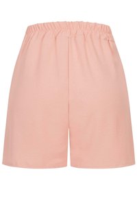 Shorts en coton rose avec une taille élastique, une coupe ample et une texture douce, au design simple et sans détails supplémentaires.