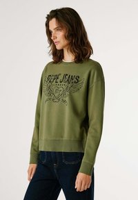 Felpa verde oliva con scollatura rotonda, polsini e orlo a coste. Presenta una stampa grafica nera con la scritta "Pepe Jeans London" accompagnata da accenti di ali.