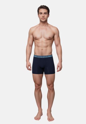 Navy boxer briefs with a blue waistband featuring "Emporio Armani." The fabric appears smooth, with a snug fit and short leg length.
