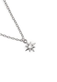 Silverhalsband med en stjärnformad hänge som har en central klar sten, omgiven av spetsiga tips och en texturerad yta.