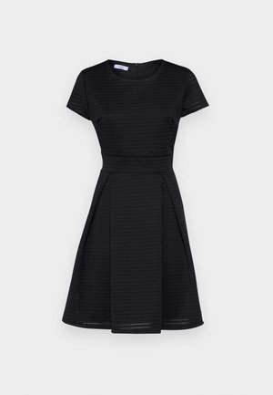 Robe noire à manches courtes avec un haut ajusté et une jupe évasée, présentant un tissu texturé et une fermeture éclair cachée à l'arrière. Design simple, sans motifs.
