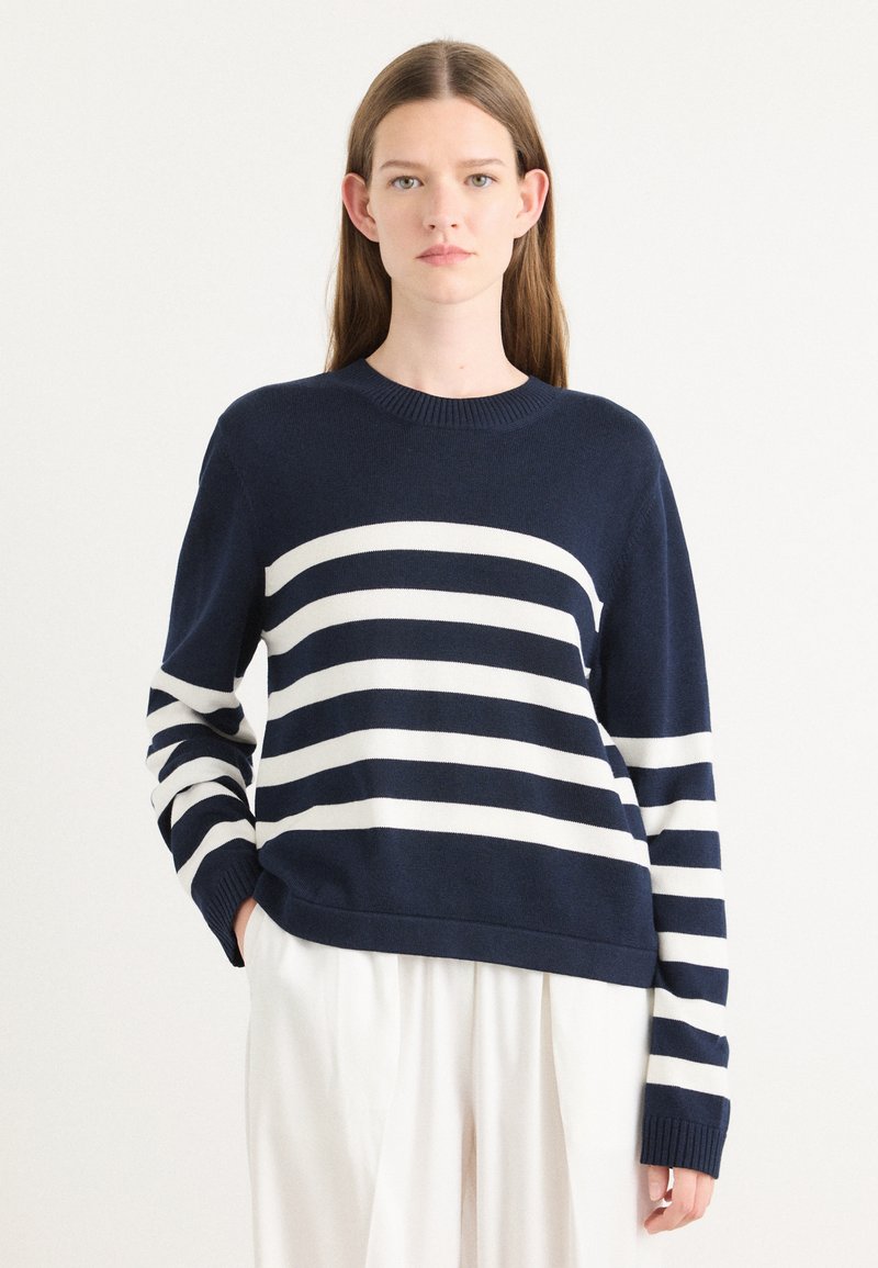 Sweater azul-marinho com riscas horizontais brancas, com decote redondo e mangas longas. Material de malha suave com punhos canelados.