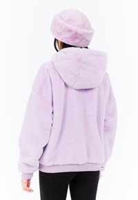Lila fleece-huppari, jossa on huppu, pehmeä texture ja ribbed hihansuut. Yhdistetty vastaavan lilan värisen pipo hatun kanssa.