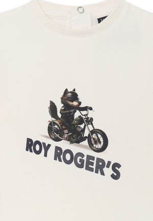 T-shirt bianca in cotone con una grafica di un lupo che indossa occhiali da sole e guida una motocicletta, con il testo "ROY ROGER'S" in bold lettere nere.