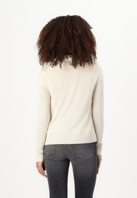 Beige langärmliger Strickpullover mit gerippten Bündchen und Saum, von hinten gezeigt. Besitzt eine glatte Textur und klare Linien.