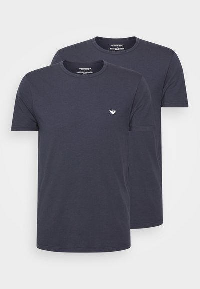 Two navy blue crew neck t-shirts made of cotton, featuring short sleeves and a small white logo on the chest. Smooth texture.