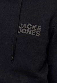 Czarna bluza z kapturem o teksturowanym wykończeniu i zamek błyskawiczny z przodu. Na piersi znajduje się tonalne logo "JACK & JONES". Miękki materiał.
