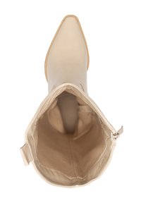 Bota de cuero beige hasta el tobillo con punta afilada, textura suave, forro interior y detalle de cremallera lateral. La suela es ligeramente curva.