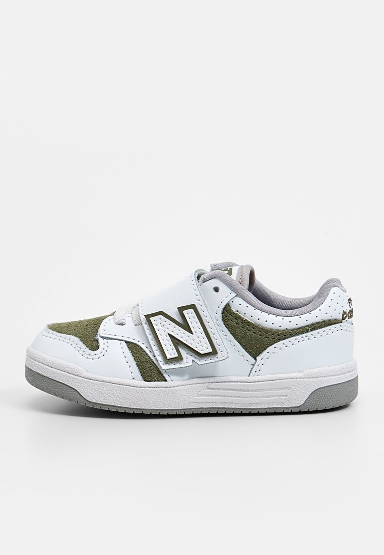 Sneaker bianca con accenti in suede verde, dotata di una fascia in Velcro, suola texturizzata e logo ricamato sul lato.