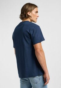 Laivansinisestä puuvillasta valmistettu lyhythihainen t-paita, jossa on pyöreä kaula-aukko ja rento malli. Suora pinta ja yksinkertainen muotoilu ilman näkyviä kuvioita tai koristeita.