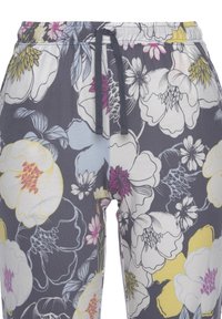 Grå joggingbyxor med blommönster, försedd med dragsko i midjan, med stora vita, rosa och gula blommor på mjukt tyg.