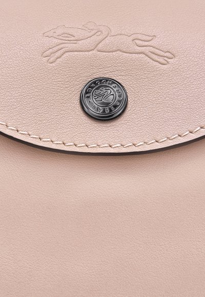 Pink leather pouch with embossed greyhound logo and black circular button closure. Features fine texture and minimal stitching detail.