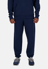 Sudadera azul marino y pantalones jogger a juego, confeccionados en una suave mezcla de algodón, con un gran bolsillo frontal, puños ribeteados y cinturilla elástica.