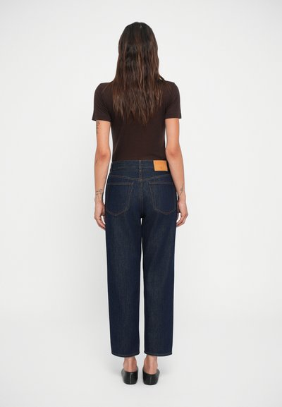 Jeans de mezclilla de pierna ancha en azul oscuro con un parche de cuero de la marca en la parte posterior, con un diseño clásico de cinco bolsillos y costuras en contraste.