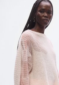 Leichter, gestrickter Pullover in einem sanften Rosa- und Cremeverlauf. Verfügt über einen runden Ausschnitt, locker sitzende Ärmel und eine zarte Textur.