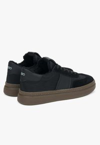 Czarne sneakersy z zamszu i syntetycznego materiału, z wyściełanym kołnierzem, gumową podeszwą oraz minimalistycznym białym logo na pięcie.