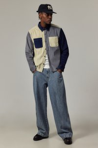 Knappt skjorte med fargeblokkdesign i grått, beige og marineblått, med to brystlommer. Kombinert med vide jeans.