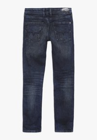 Tmavě modré džínové kalhoty s úzkým střihem, vybavené dvěma zadními kapsami, jemným třením na látce a páskem s logem.