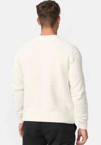 Witte gebreide pullover trui met een textuurpatroon, effen kleur, lange mouwen en geribde boorden en zoom. Achteraanzicht weergegeven.