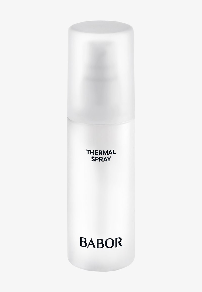 Botella de spray cilíndrica blanca con una tapa transparente. Presenta texto negro que dice "SPRAY TÉRMICO" y "BABOR" en la parte frontal.