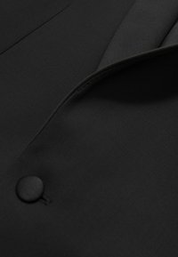 Zwarte blazer met een gladde stofstructuur, met een notched lapel en een enkele knoopdetail aan de voorkant. Eenvoudig en elegant ontwerp.