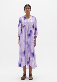Purple tie-dye dress with a V-neck and long puff sleeves. Made of lightweight fabric, featuring subtle pleats and a slightly flared hem.
