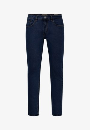 Tumedast sinine denimist teksad sirge lõikega, viie tasku disaini ja õmmeldud vöökohaga, mis sisaldab metallist nööpi ja lukku.