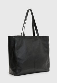 Sac fourre-tout en cuir noir avec deux longues poignées, une texture lisse, une forme rectangulaire et des détails de surpiqûres subtiles. Pas de matériel visible.