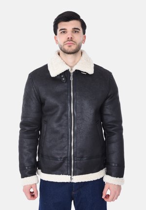 Giacca in ecopelle nera con colletto e polsini in shearling crema, dotata di zip frontale e tasche laterali, con vestibilità strutturata e texture liscia.