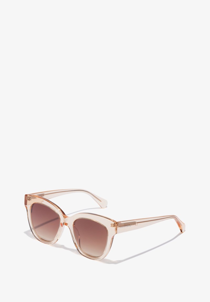 Ochelari de soare tip cat-eye cu un cadru translucid de piersici și lentile maro cu un gradient. Prezintă brațe subțiri cu accente argintii pe balamale.