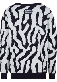 Svart och vit stickad tröja med ett vågigt abstrakt mönster. Har rundad hals och långa ärmar; mjuk textur och avslappnad passform.