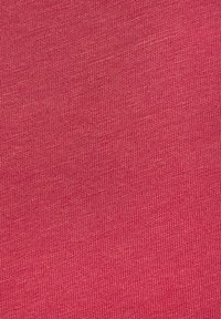 Textil in einem hellen Pinkton mit gerippter Textur und gleichmäßigem Muster, das feine, vertikale Linien über die gesamte Oberfläche aufweist.