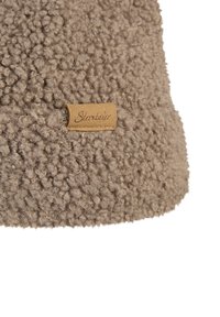 Close-up of beige, curly fleece fabric with a small tan rectangular label stitched, showing "Sterntaler" brand name.
