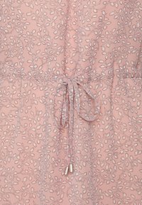 Vaaleanpunainen kangasmekko, jossa on valkoisia kukkakuoseja. Mekossa on vyötäröä korostava nyöri, jossa on yhteensopivat kiristysnauhat ja hopeiset päät. Pehmeä ja kevyt rakenne.