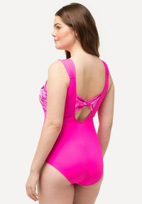 Roze één-delig zwemkostuum met brede banden, een gemusterde voorkant en een rug met uitsnijding en een geknoopt detail. Glad, rekbaar materiaal.