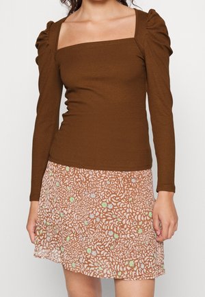Top long à manches longues marron côtelé avec un décolleté carré et des épaules bouffantes, associé à une jupe transparente à motifs pêche avec des détails floraux abstraits.
