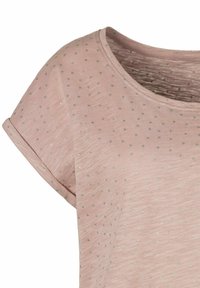 Helles rosa T-Shirt mit kurzen, gerollten Ärmeln, das eine subtile Textur und verstreute silberne Punkte für Details aufweist. Rundhalsausschnitt.