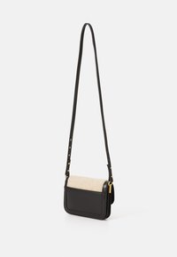 Svart läder crossbody-väska med en beige texturerad klaff, justerbar rem och guldfärgade metalldetaljer. Kompakt rektangulär design.