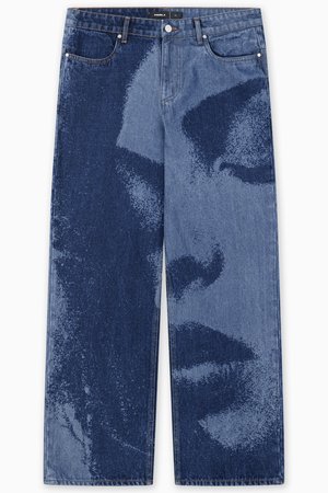 Weit geschnittene Jeans aus Denim mit einem Farbverlauf in Blau, das ein grafisches Muster eines Gesichts zeigt, fünf Taschen und einem Knopfverschluss.