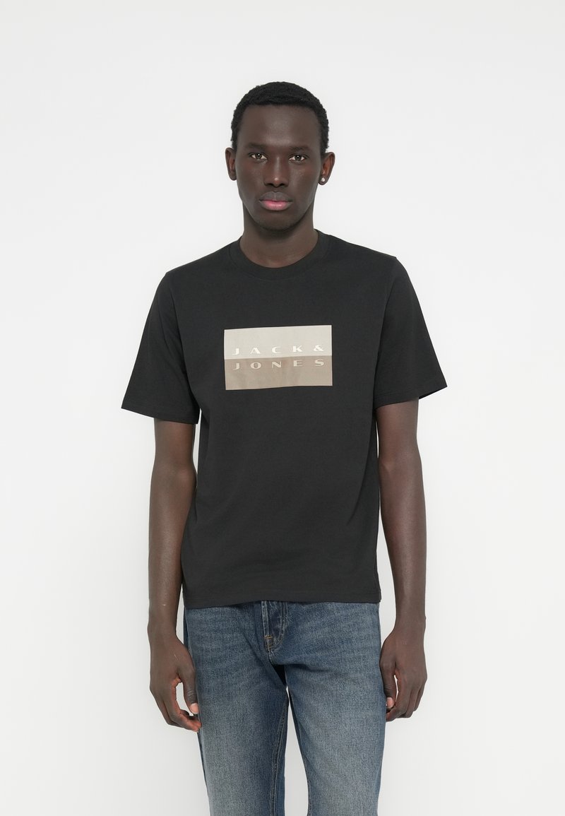 Μαύρο βαμβακερό t-shirt με κοντά μανίκια, με ορθογώνιο λογότυπο "JACK & JONES" σε χρώμα κρεμ και χρυσό τυπωμένο στο μπροστινό μέρος.