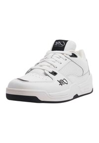 Sneaker bianco con pannelli laterali in pelle perforata e un accento nero sulla suola. Presenta un design con lacci e un logo sul lato esterno.
