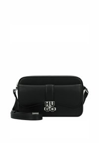 Borsa a tracolla in pelle nera con una texture liscia, patta frontale curva e hardware con logo argentato. Include una tracolla regolabile. Forma rettangolare.